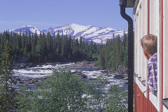 Pojke i fönstret på Kvikkjokks fjällstation beskådar fjällmassivet Bårdde i Sarek.